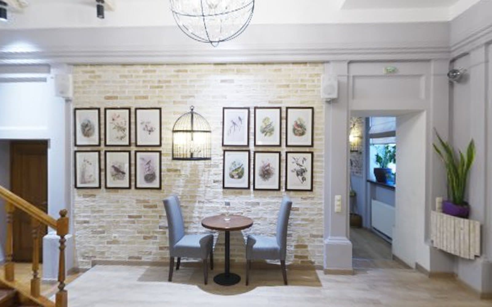Café corner with a table for two and framed botanical prints